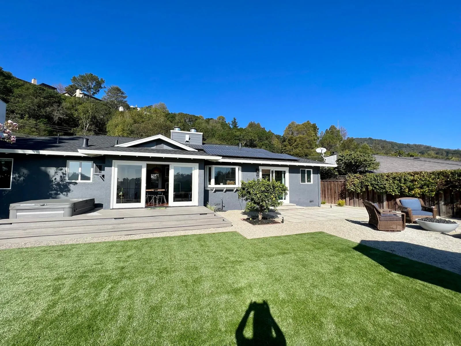 Backyard with artificial turf, patio and deck on a sunny day