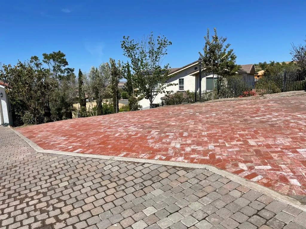 Red brick paver driveway with a gray cobble border